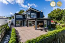 Master Builders gold award winner - Category: New Home $1.5 million - $2 million
Gold for Auckland, Northland, Coromandel 
Top 100 for NZ

Coastal living doesn’t get much better than this — start your day by strolling to the beach for a morning dip then freshen up back home in the private outdoor shower, before enjoying breakfast on the sun-soaked deck. On the weekends it’s all about entertaining, with a walk-in commercial chiller to store the drinks and living spaces which flow seamlessly out to the partially covered deck, where the centrepiece is the Argentinian-style brick grill. Light filters into the 306sqm home, making details like the polished concrete floors and the solid walnut used on the wide staircase shine. The flooring in the entryway is also walnut as is the elevator flooring (accessibility is another highlight of this home). There’s plenty of room for family life, with two large living spaces on the open-plan ground floor partitioned off from the kitchen and dining area with carefully placed built-in shelving. Downstairs also houses a laundry, garage and guest toilet, and a scullery incorporating that famous walk-in chiller. Upstairs are four bedrooms, including a spacious main bedroom with ensuite, plus a study and family bathroom. Importantly, the house is also set up for a sustainable future, with solar panels and an EV car charging station.