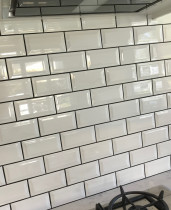 Beveled white subway black grout completed by Just Splashbacks - Female Tiler