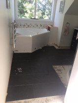 Bathroom: floor and wall at the early state of tiling process