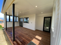 Sheltered Sophistication - This stunning covered deck creates the ultimate all-weather extension to the living space.
The rich, warm tones of the hardwood decking contrast beautifully with the crisp white weatherboards and sharp, black joinery.
Integrated down lights in the ceiling provide perfect ambiance for evening relaxation or entertaining.
It's a sheltered, sophisticated space designed for year-round enjoyment of the outdoors.
