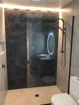 New tiled bathroom by Bathroom and Tiling Ltd - Ground floor bathroom 600x600mm tiles to level entry walk in tiled shower with hexagon tile feature wall in in out pattern.