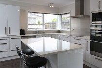 Jag Kitchens - A modern kitchen design with crisp white stone benchtops exudes functionality and comfort.You can read about this kitchen makeover here - https://www.jagkitchens.co.nz/new-life-for-outdated-kitchen/