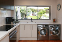 Jag Kitchens - Having the laundry incorporated into the kitchen was one of the more significant features of the kitchen. Because the benchtop space above the washer and dryer would double up as a server for outdoor entertaining, the depth needed to be just right so it was easy enough to reach over.